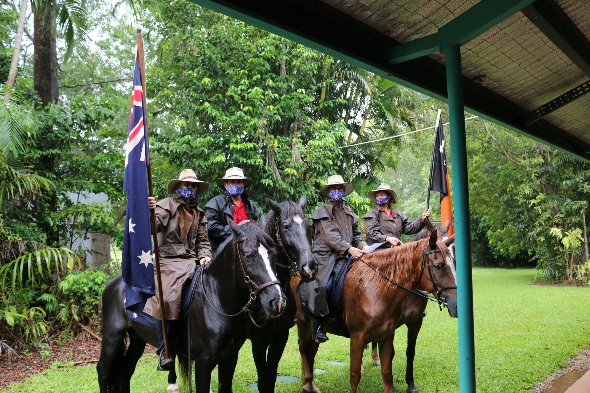 A group of people wearing masks are riding horses.